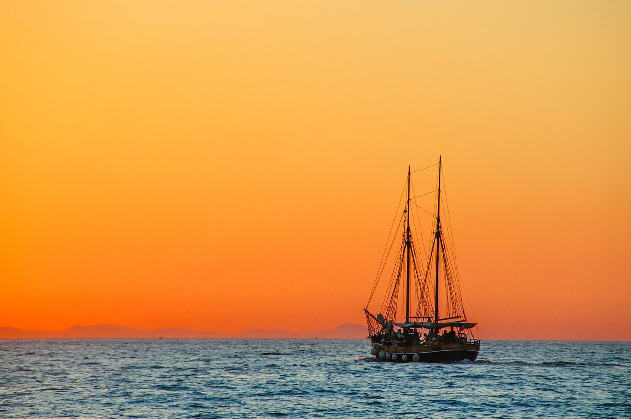 Yacht Surveys by Rea Associates - view of yacht on the ocean and orange skies